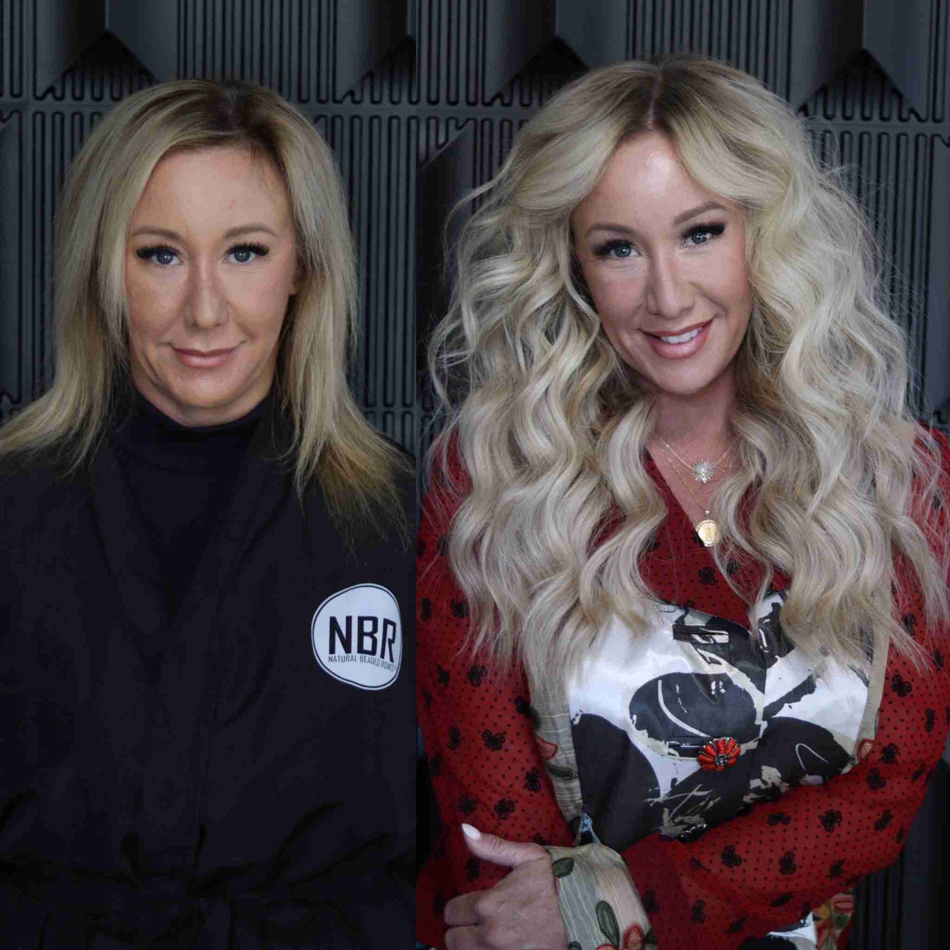 Two blonde women are standing next to each other in front of a wall.