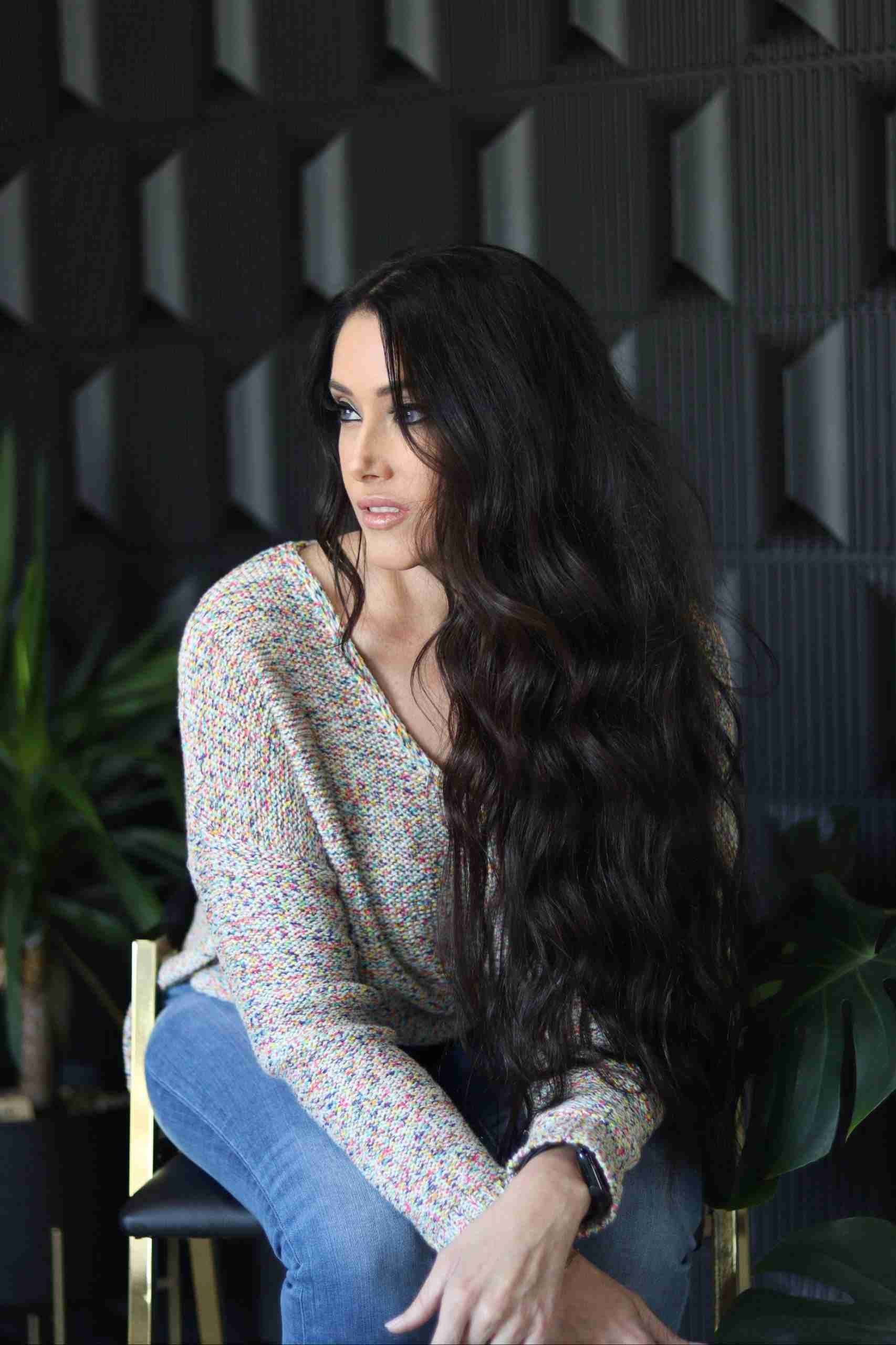 A woman with long hair is sitting on a chair