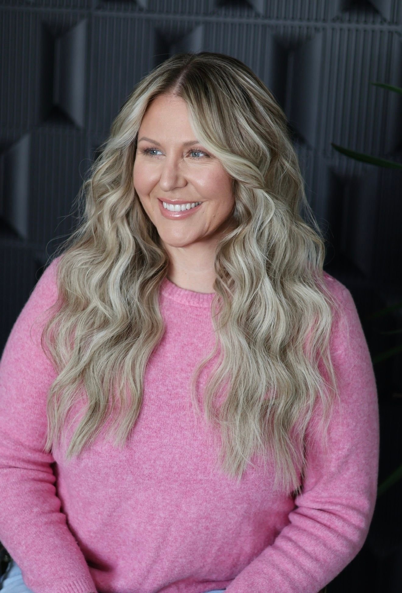 Blonde client with customized natural-looking hair extensions at Glam.Is.On Salon