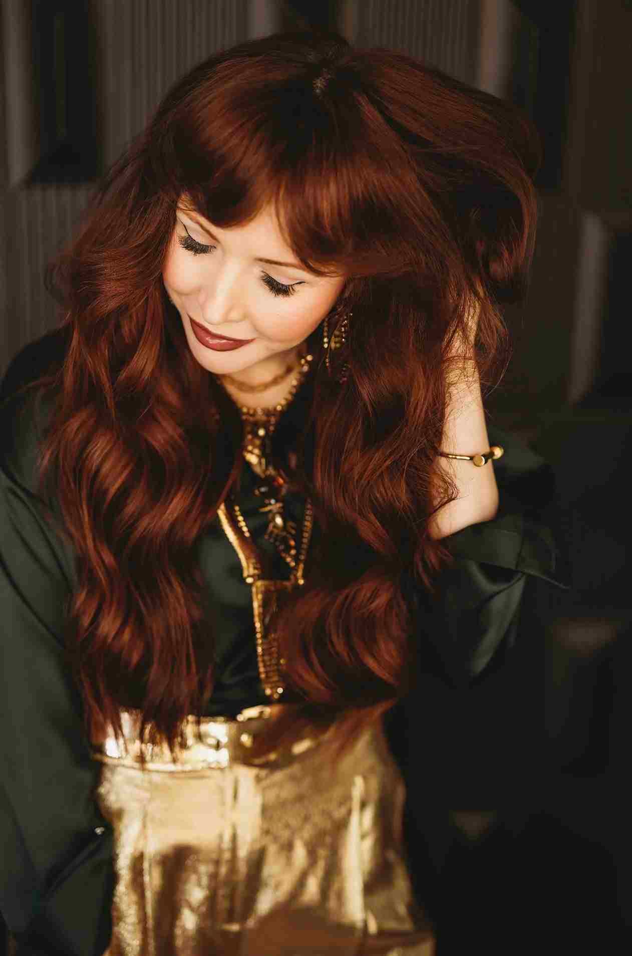 A Glam.Is.On guest with long auburn hair
